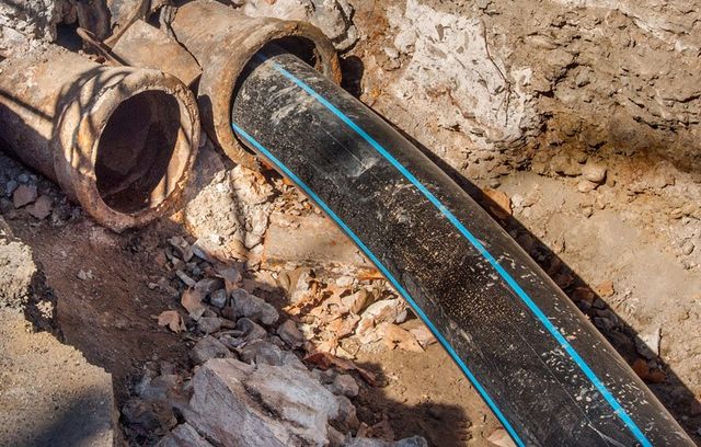 A new pipe being fitted inside an old, rusted underground sewer line